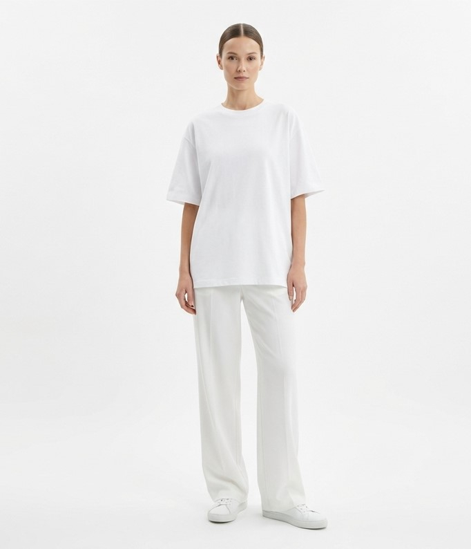Женщина в полностью белом минималистичном образе с футболкой оверсайз и широкими брюками